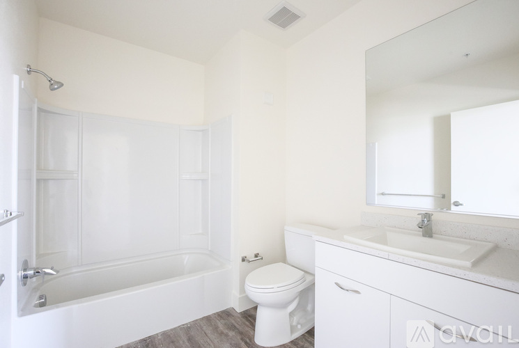 A white bathroom with a toilet, sink, and bathtub.