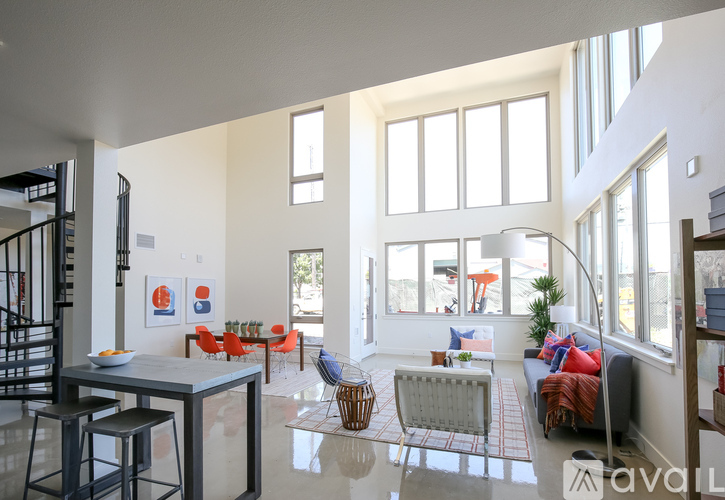A living room with a staircase on the left and a dining area in the middle.
