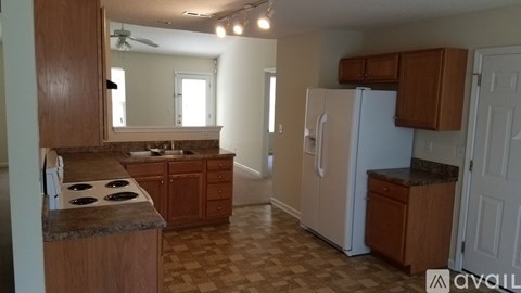 A kitchen with wooden cabinets and a checkered floor.