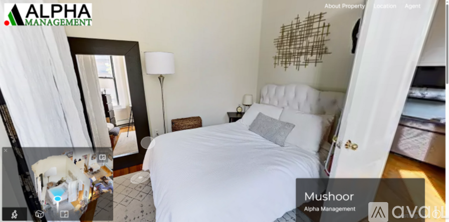 A bedroom with a large bed and a lamp.