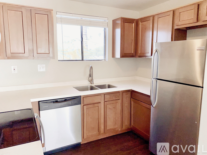 A kitchen with wooden cabinets and a stainless steel refrigerator.