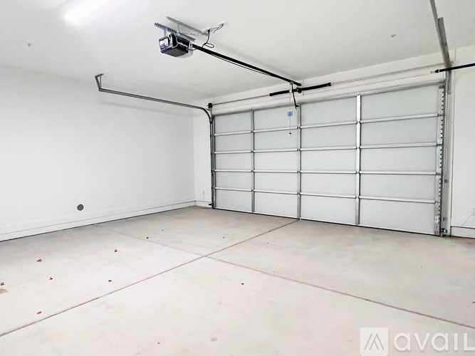 A spacious garage with a white door and a ceiling light.
