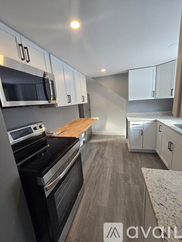 A kitchen with a stove top oven and microwave above it.