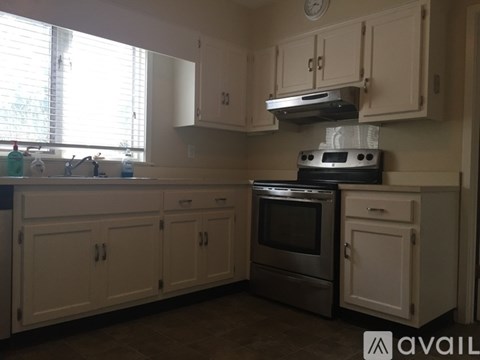 A kitchen with white cabinets and a stove top oven.