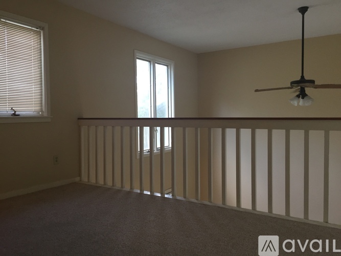 Empty room with a window and a ceiling fan.
