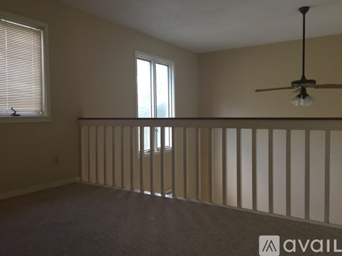 Empty room with a window and a ceiling fan.