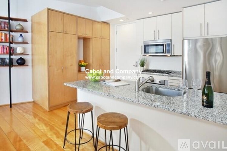 A kitchen with a wooden cabinet and a granite countertop.