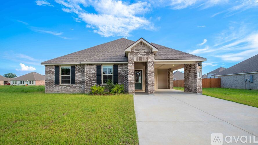 A house with a front yard and a clear sky above.
