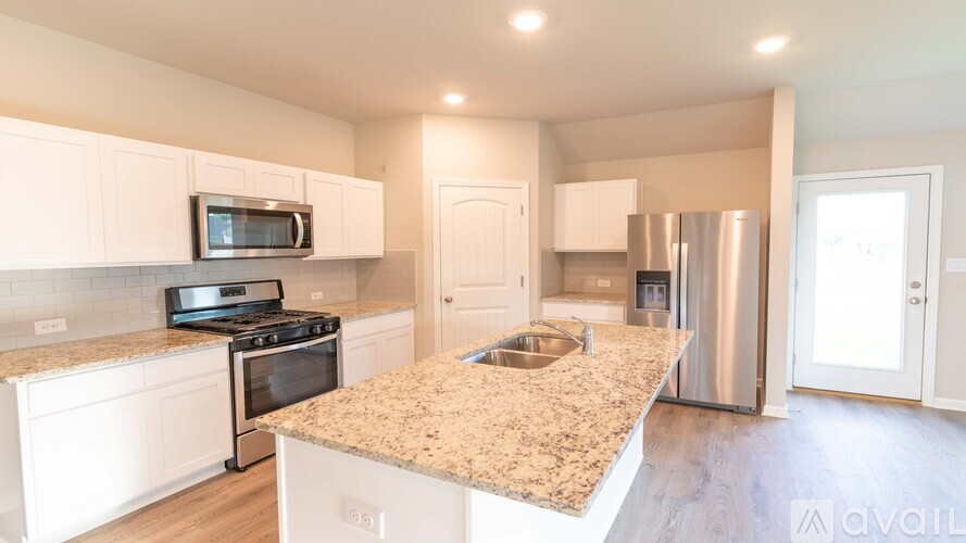 A kitchen with a granite countertop and stainless steel appliances.