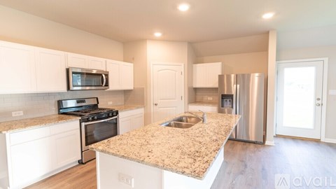 A kitchen with a granite countertop and stainless steel appliances.