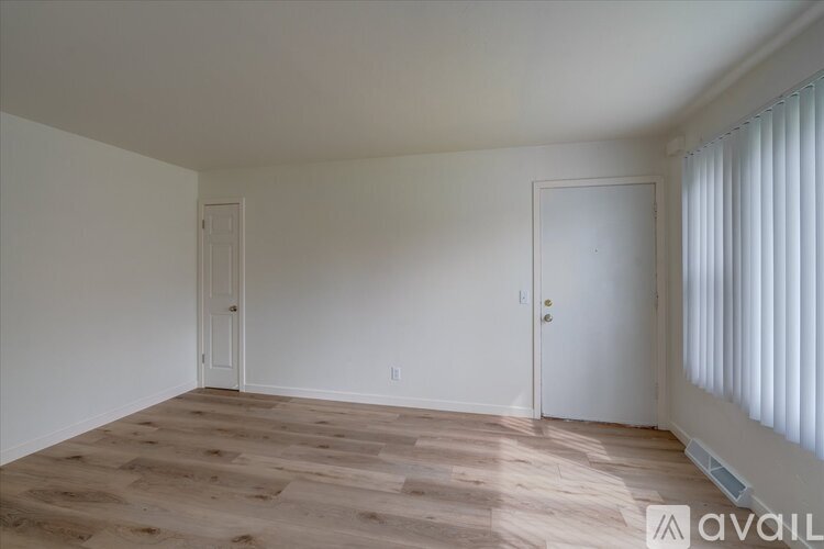 A room with wooden flooring and two white doors.
