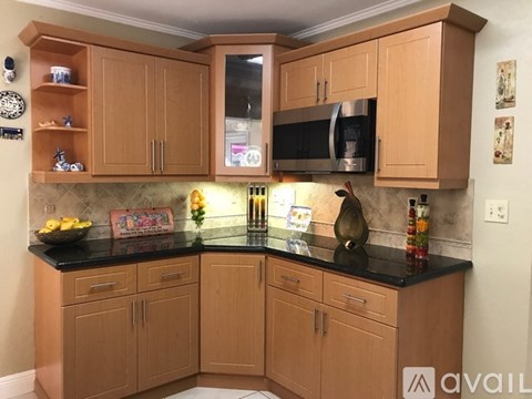 A kitchen with wooden cabinets and a black countertop.