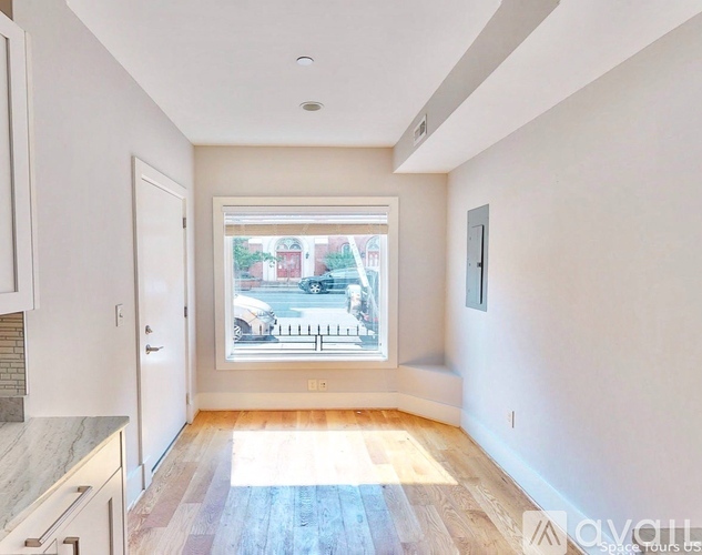 A sunny room with a window showing a street view.