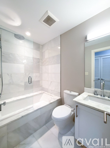 A bathroom with a toilet, sink, and shower.
