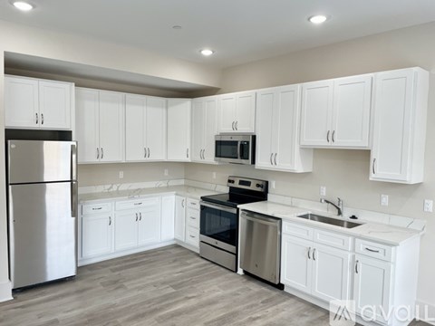 A kitchen with white cabinets and stainless steel appliances.