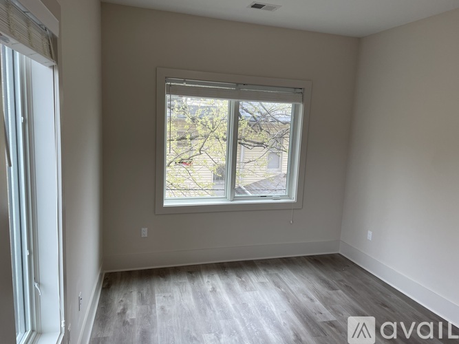 A room with a window and a wooden floor.
