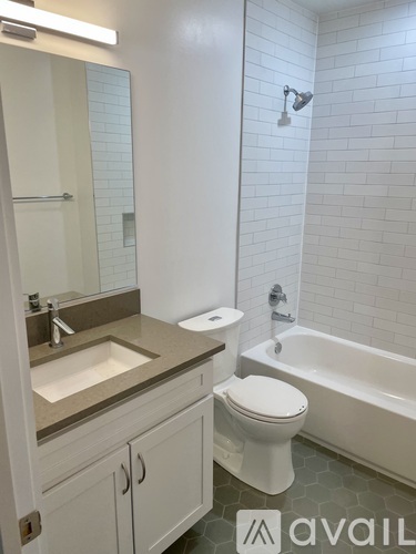 A white toilet sits next to a white bathtub in a bathroom.