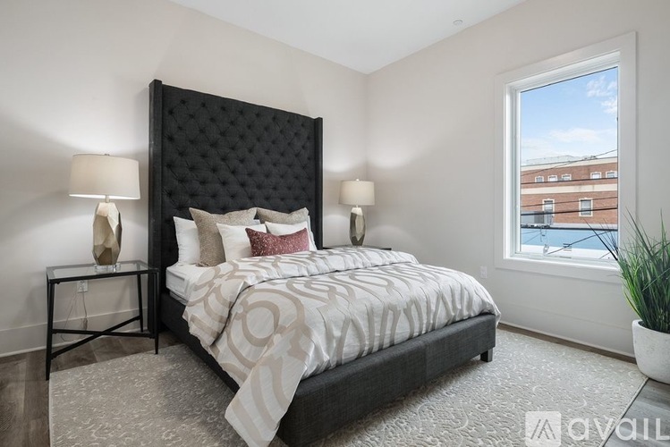 A bedroom with a large bed and a window overlooking a cityscape.