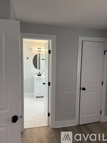 A kitchen with a white countertop and wooden flooring.