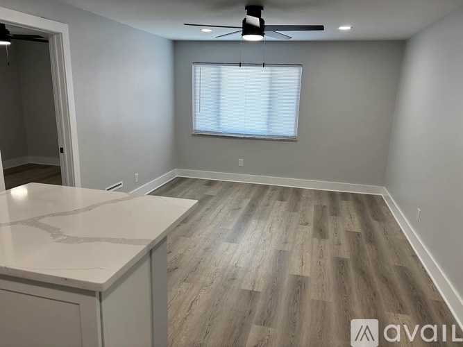 A room with a white door, a window, and a wall-mounted air conditioner.