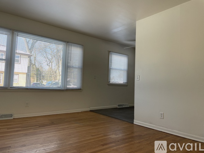 A room with wooden floors and two windows.