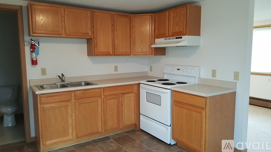 A kitchen with wooden cabinets and a white stove top oven.