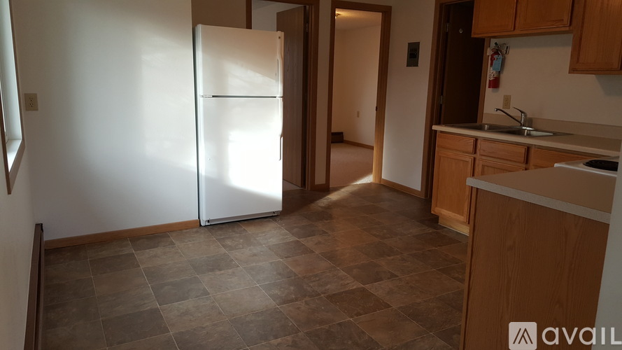 A kitchen with a tiled floor and a refrigerator.
