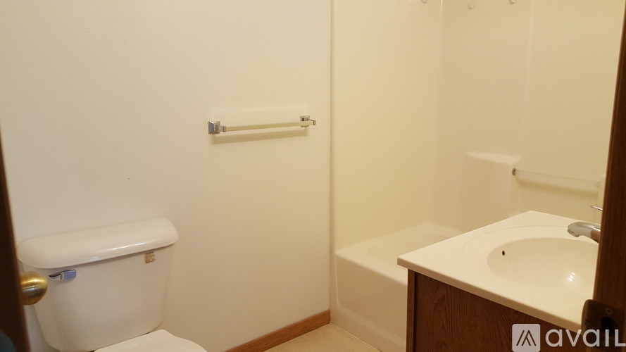 A white toilet is next to a white sink in a small bathroom.