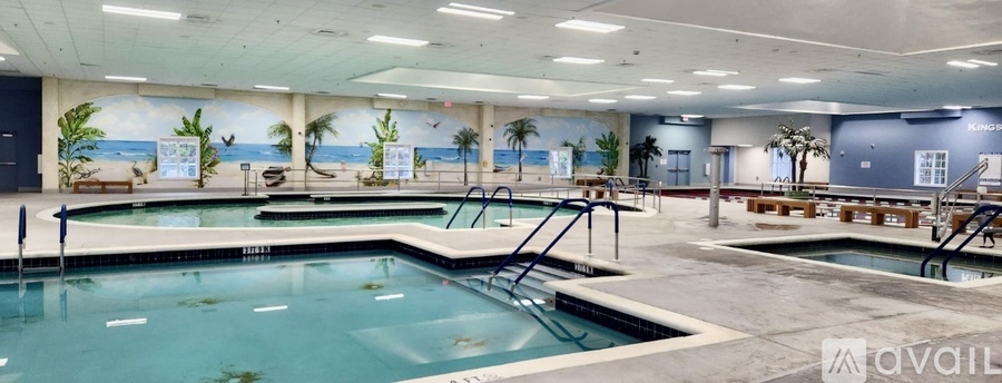 A large indoor swimming pool with a mural on the wall.