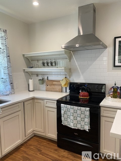 A kitchen with a black stove top oven and white cabinets.
