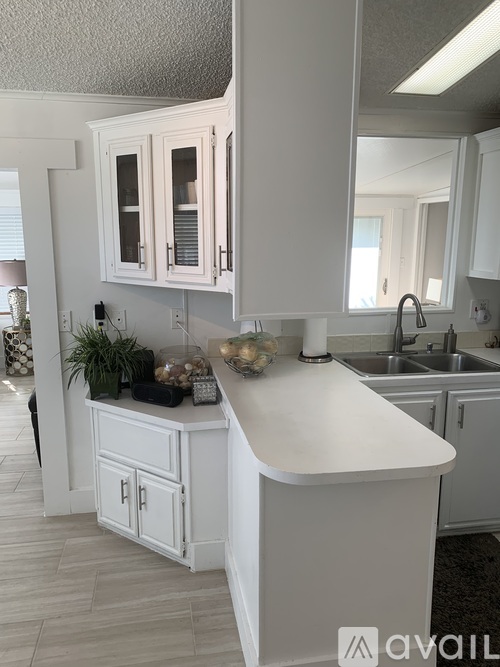 A kitchen with white cabinets and a white island.