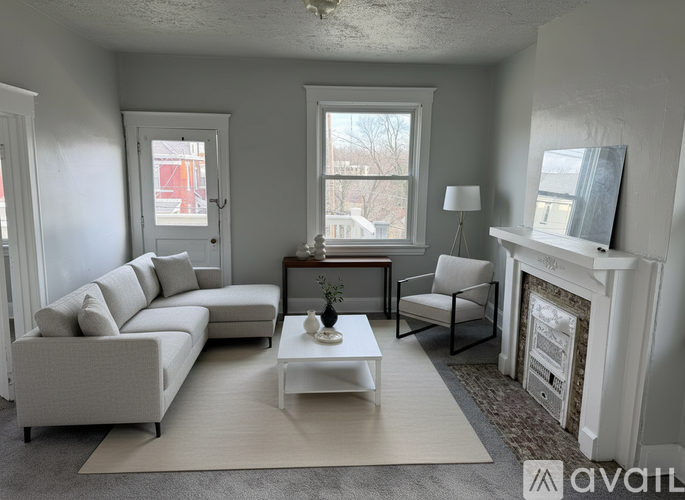 A living room with a white couch, a coffee table, and a fireplace.
