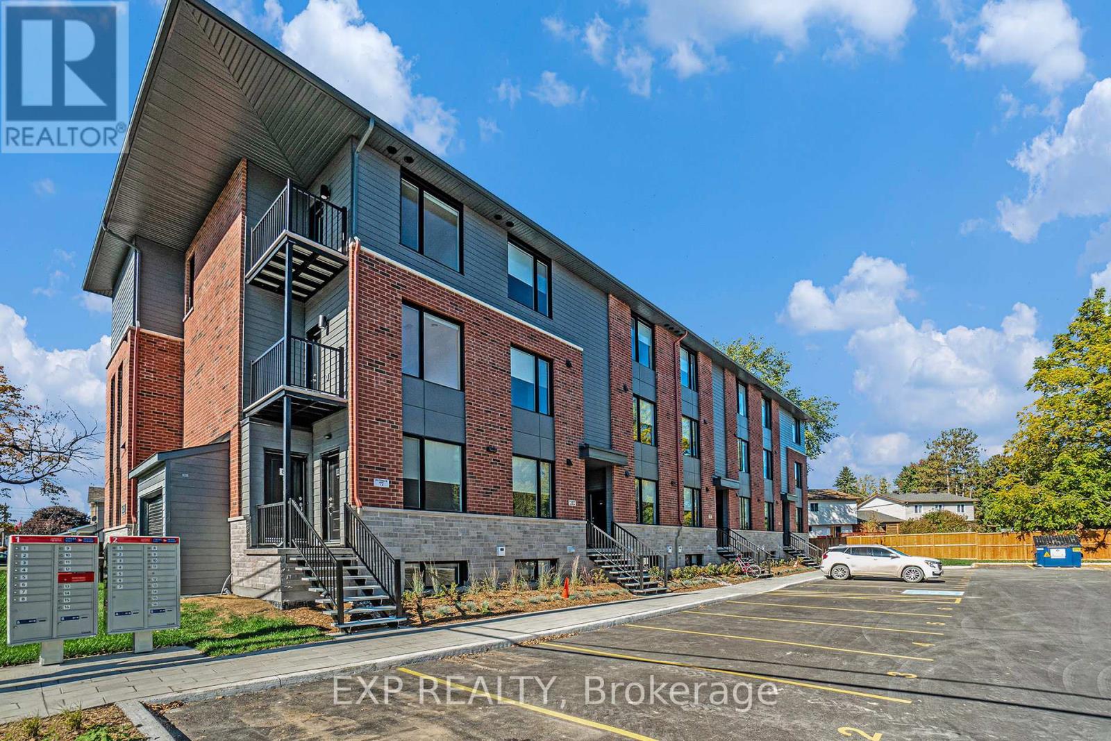 A building with the sign EXP REALTY Brokerage in front of it.