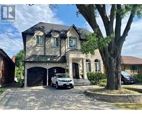 A house with a car parked in front and a tree to the right.