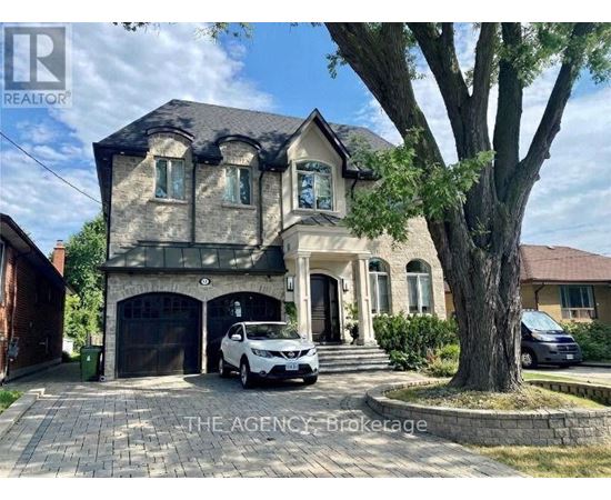 A house with a car parked in front and a tree to the right.