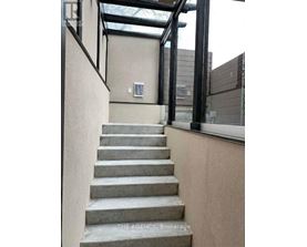 A set of concrete stairs leads up to a glass roofed area.