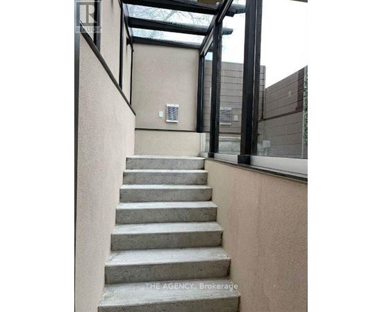 A set of concrete stairs leads up to a glass roofed area.