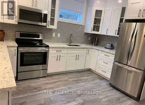 A kitchen with white cabinets and stainless steel appliances.