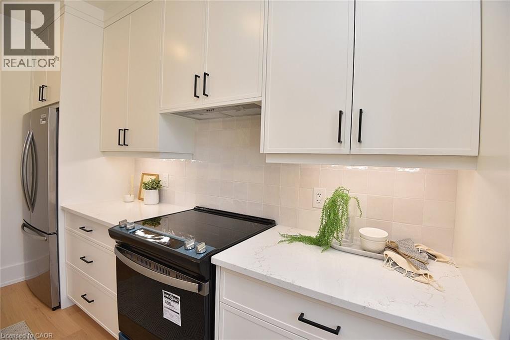 A white kitchen with a black dishwasher and a refrigerator.