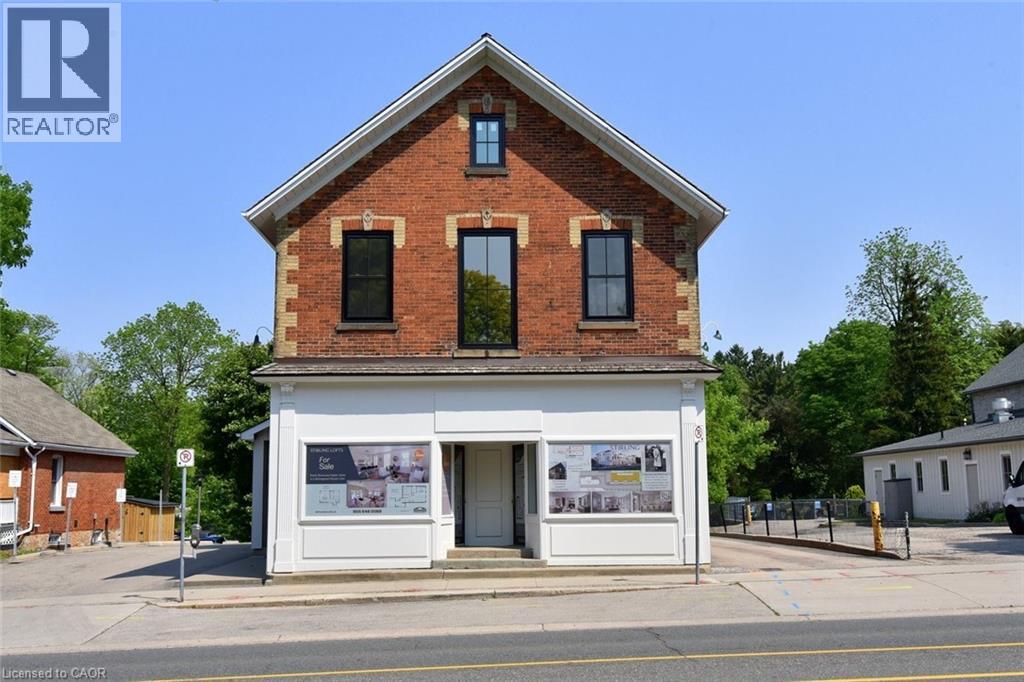A small brick building with a white door and windows.