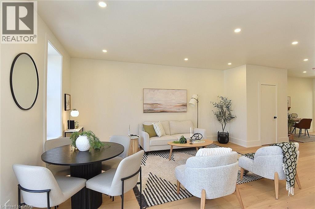A living room with a black table and white chairs.