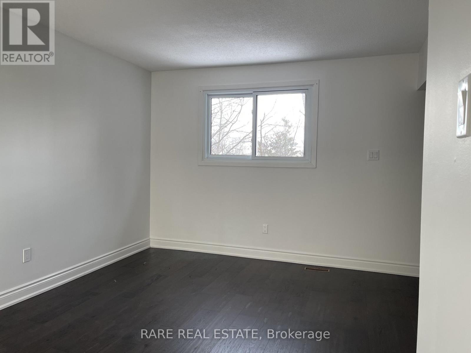 A room with a window and a wooden floor.