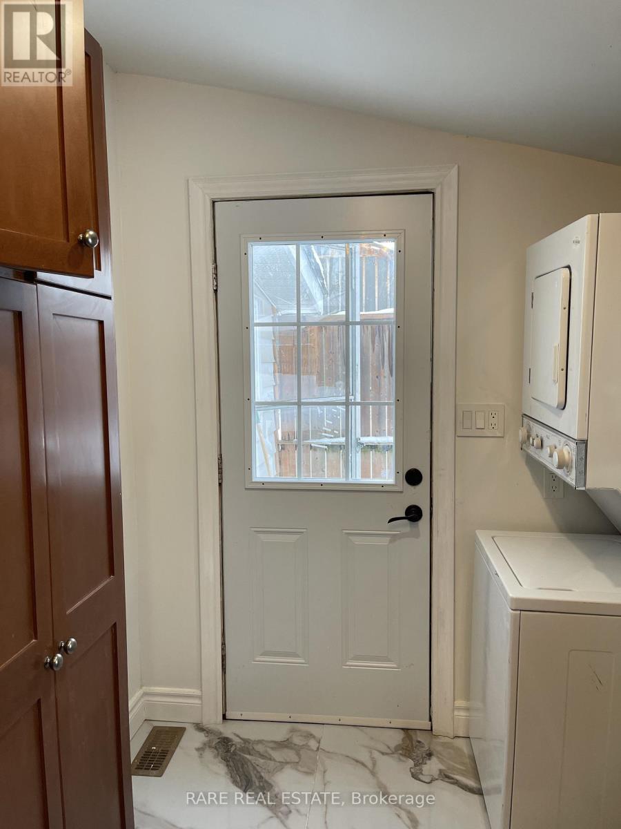 A white door with a black handle is in the middle of a room.