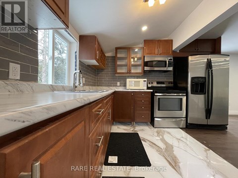 A kitchen with wooden cabinets and a marble countertop.
