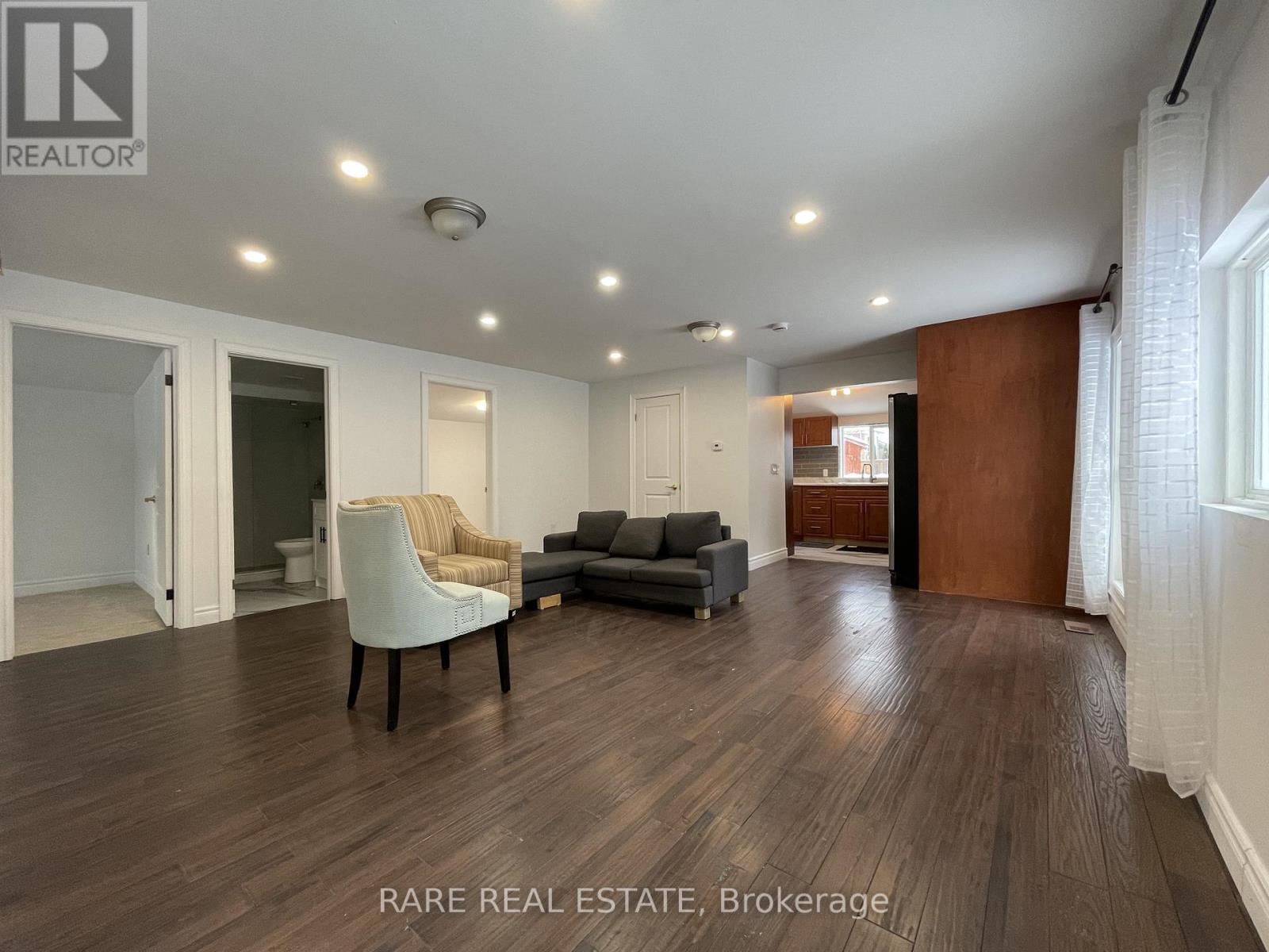 A spacious living room with wood flooring and modern furniture.