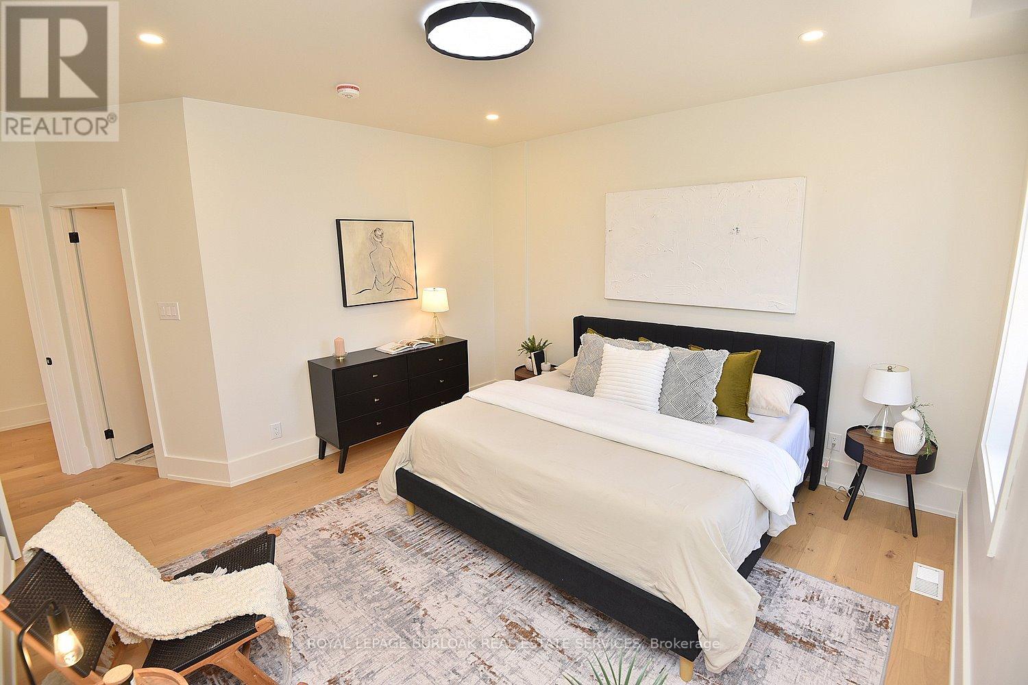 A bedroom with a large bed and a painting on the wall.
