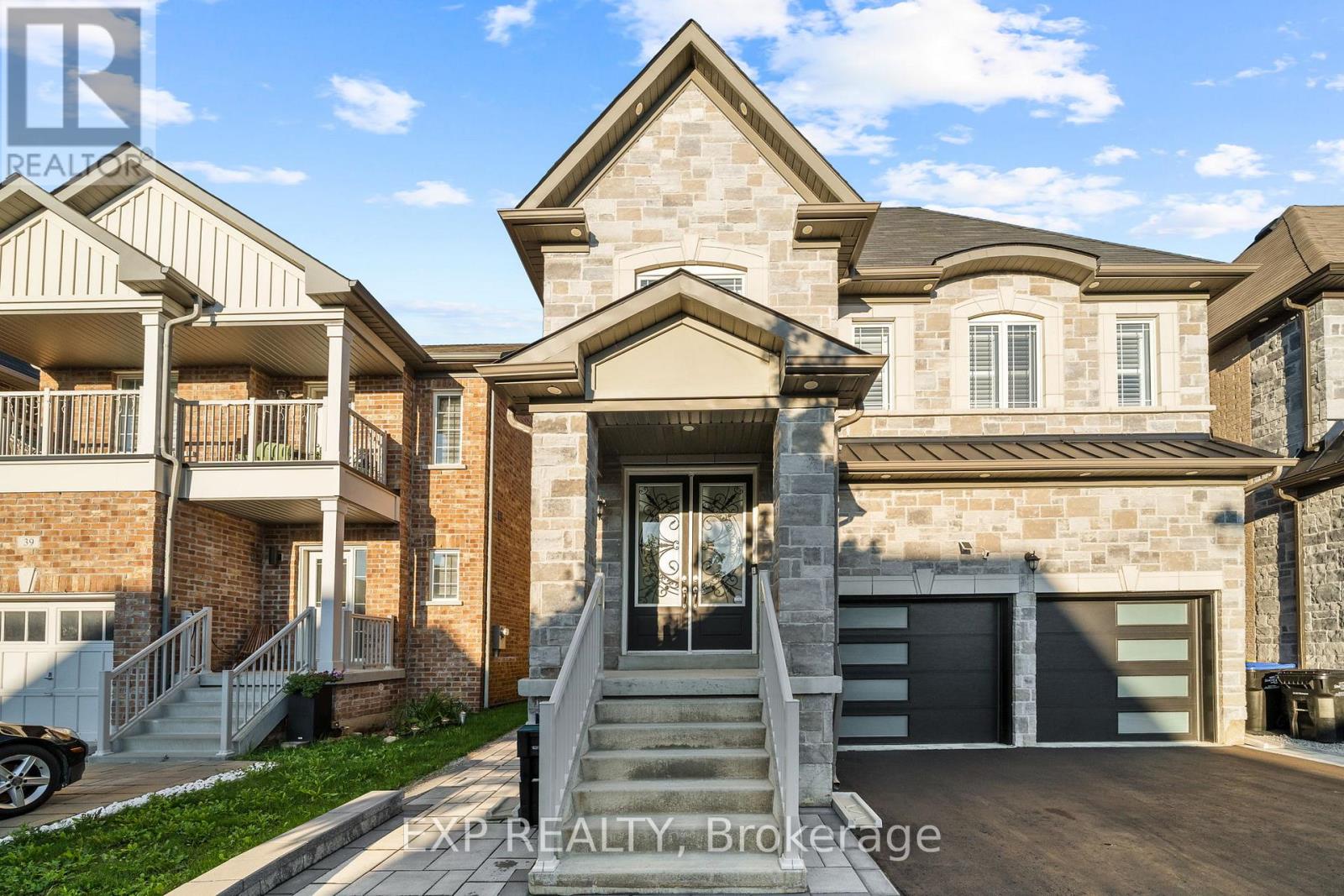 A large house with a stone facade and a garage is for sale.