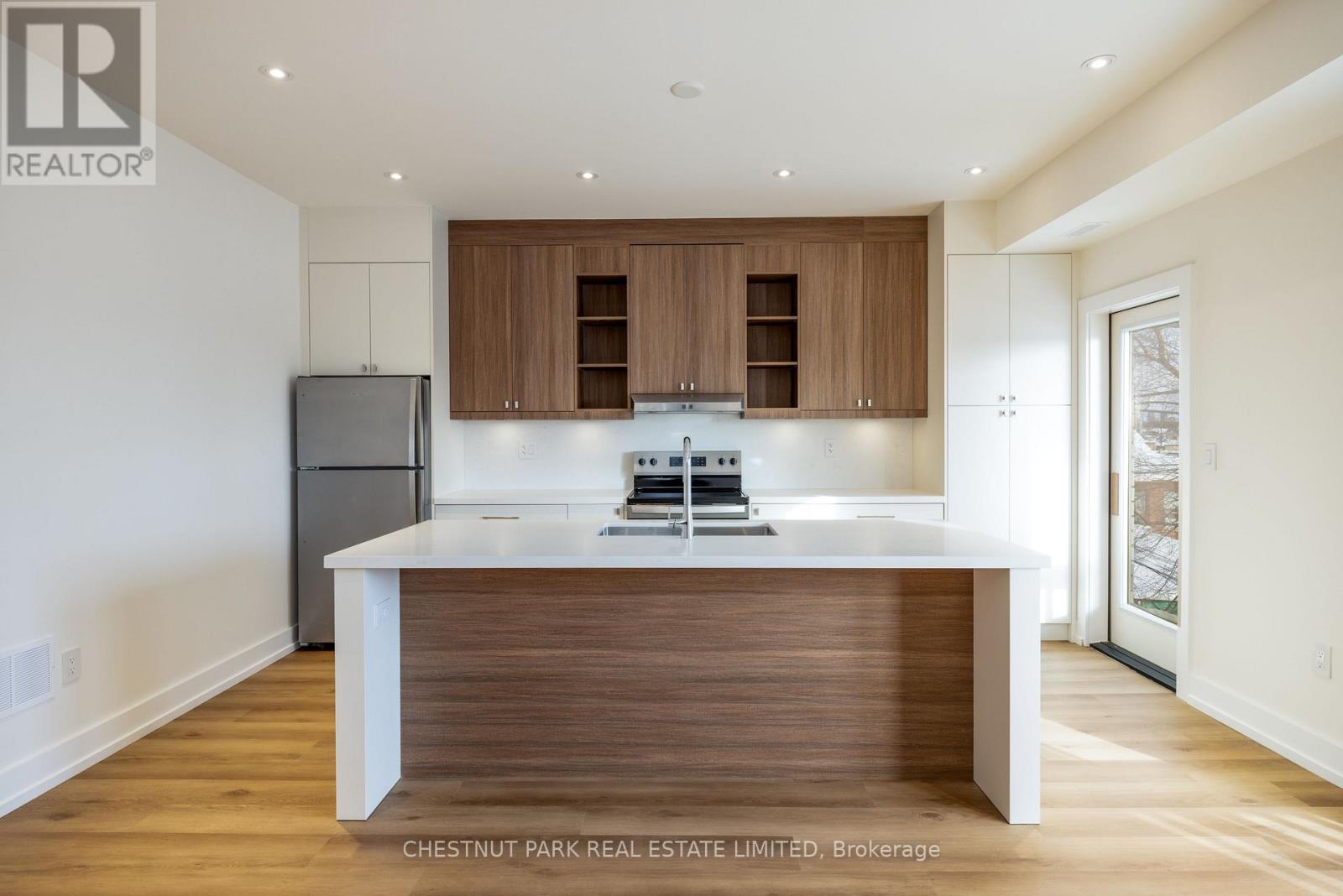 A modern kitchen with wooden cabinets and a white island.