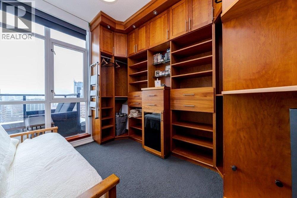 A bedroom with a large bed and a built-in wardrobe.