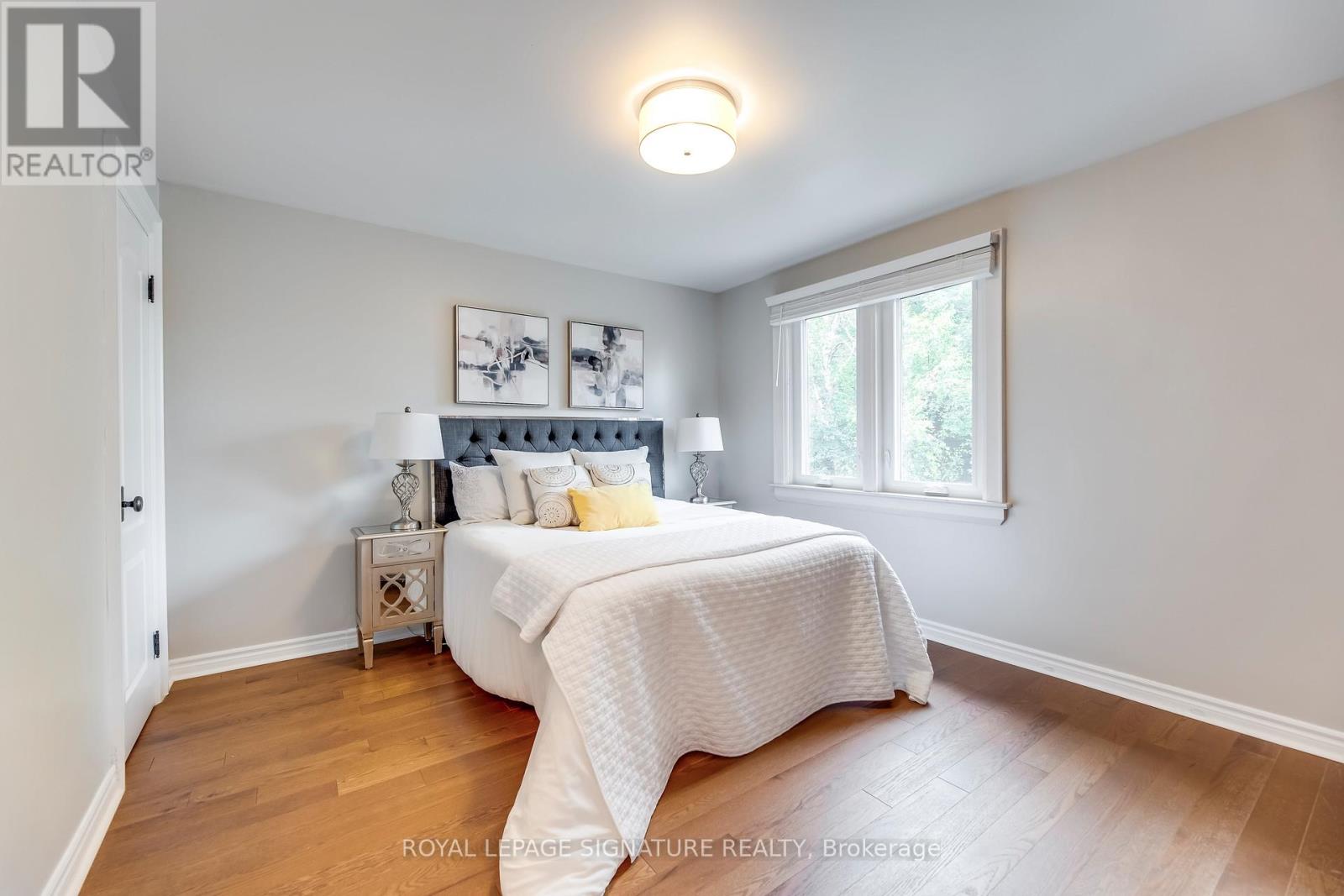 A bedroom with a bed, nightstand, and lamp.